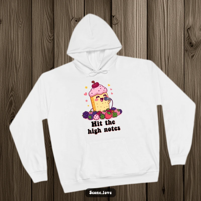 Funny scone singing with a microphone performing for a small crowd of berries, a humorous and warm hoodie.